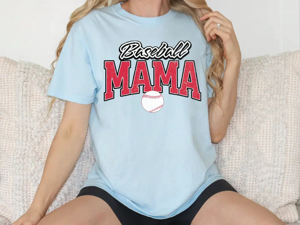 a woman sitting on a couch wearing a baseball mama shirt