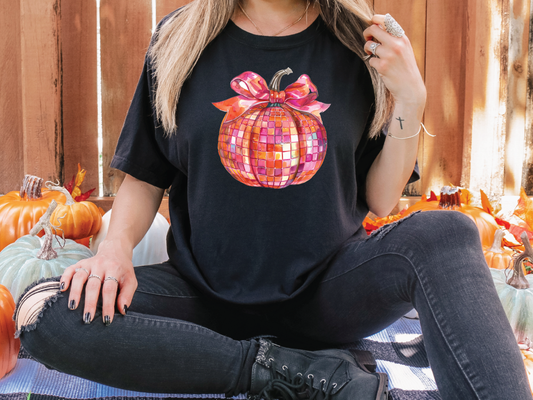 a woman sitting on the ground in front of pumpkins