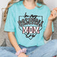 a woman in a baseball mom shirt sitting on a couch