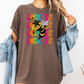 A woman wearing a brown t-shirt with a graphic of a bee and the word "JACKETS" printed on it, along with a denim jacket.