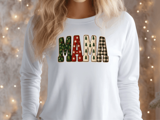 A woman wearing a white long-sleeved shirt with the word "MAMA" printed on it in a festive, holiday-themed font.