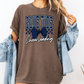 a woman wearing a brown tshirt with a blue ribbon on it