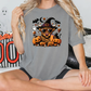 a woman sitting on a bed wearing a halloween shirt