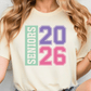 A woman wearing a white t-shirt with the text "SENIORS 20 26" printed on it.
