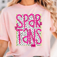 A woman wearing a pink t-shirt with the text "SPAR TANS" printed on it.