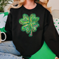 a woman sitting on a couch wearing a black sweater with a green shamrock on it