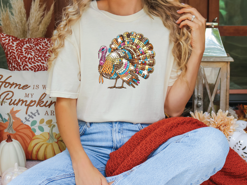 a woman sitting on a couch with a turkey t - shirt on