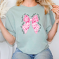 a woman sitting on a chair with a pink bow on her shirt