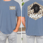 a man wearing a blue t-shirt with a graphic design on the back. The design features a black bird, likely a raven, with a camouflage pattern. The word "RAVENS" is written above the bird.