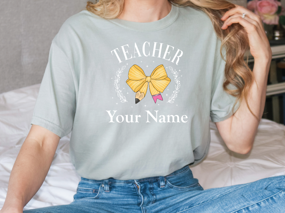 a woman sitting on a bed wearing a t - shirt that says teacher your name