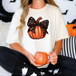 a woman sitting on a bed holding a pumpkin mug