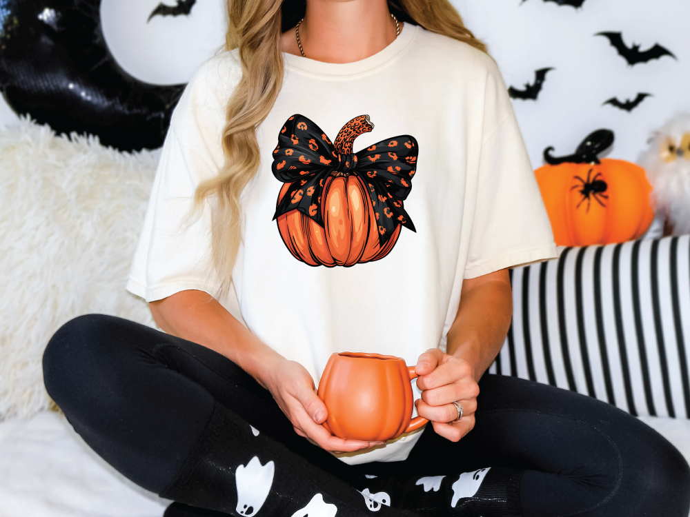 a woman sitting on a bed holding a pumpkin mug