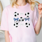 a woman wearing a pink shirt with soccer balls on it