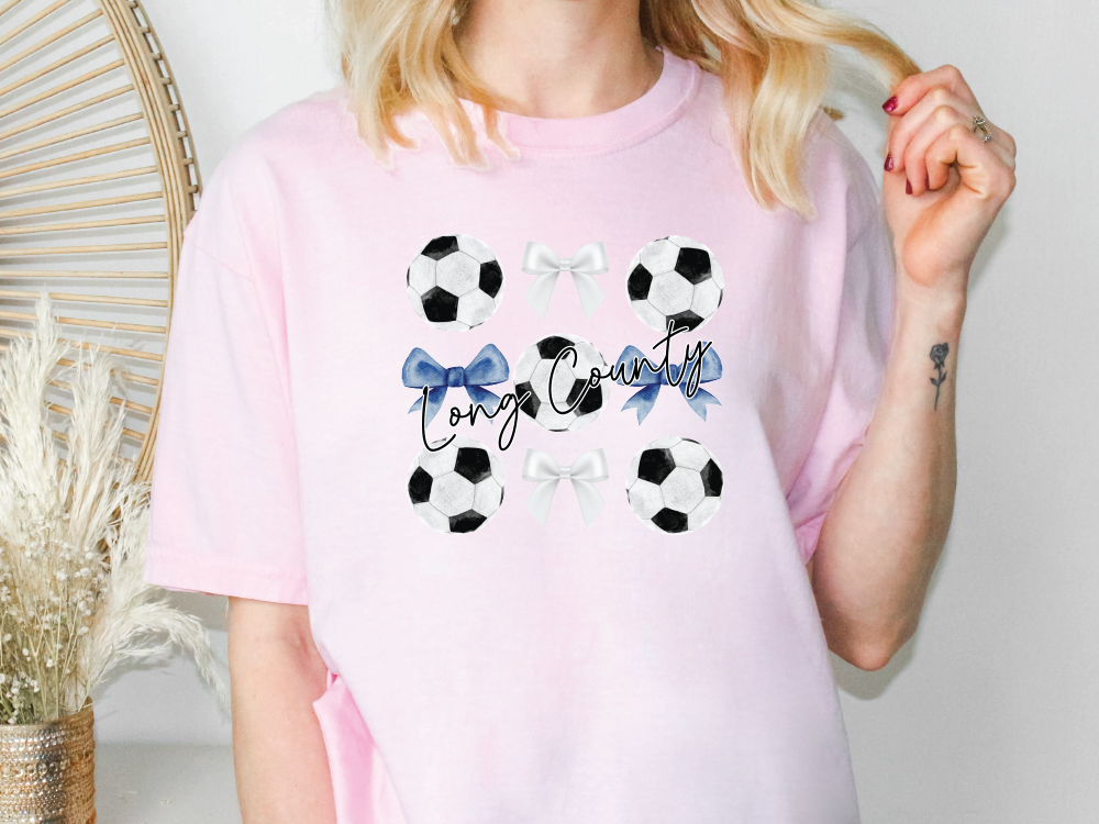 a woman wearing a pink shirt with soccer balls on it