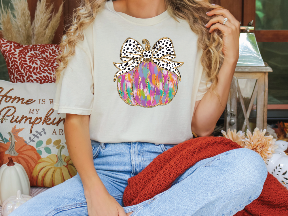 a woman sitting on a couch wearing a t - shirt with a bow on it