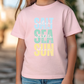 a little girl wearing a pink shirt and jeans