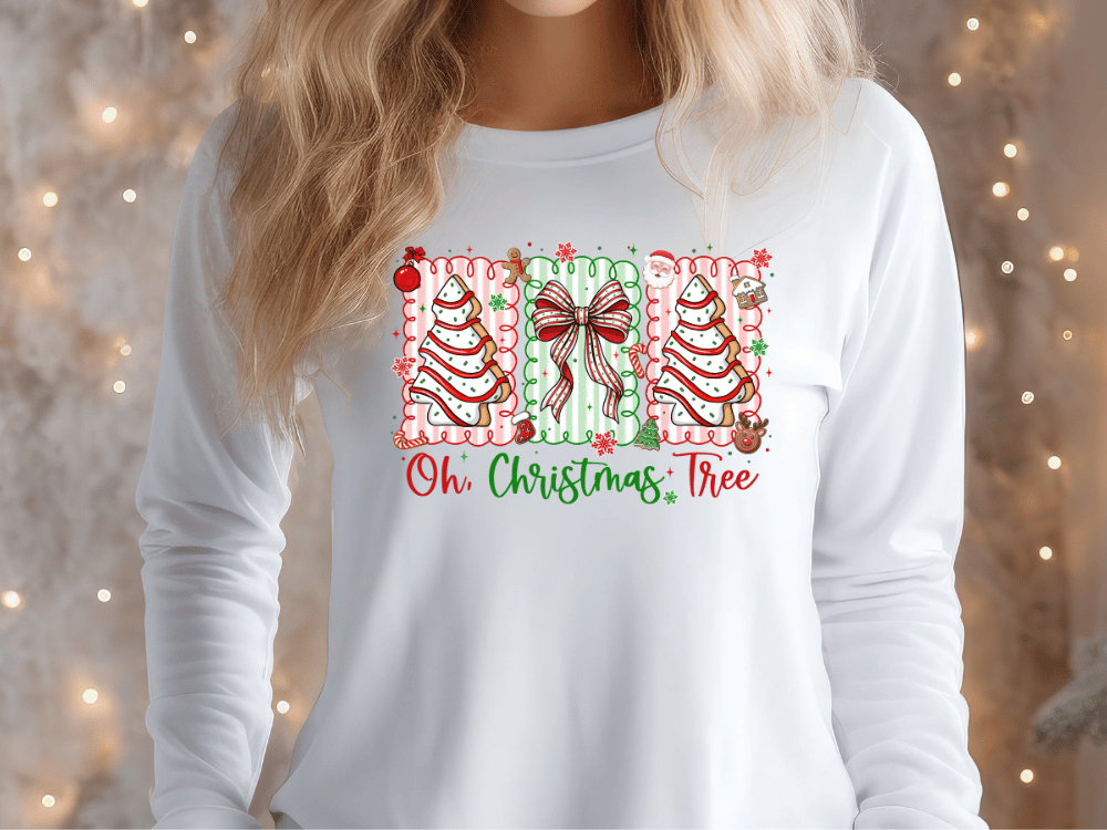 A woman wearing a white long-sleeved shirt with a Christmas-themed graphic design on it.