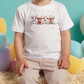 a little boy sitting in front of a bunch of balloons