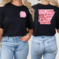 two women wearing black tshirts with pink designs on them