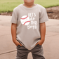 A young boy wearing a t-shirt with the text "LET'S DO THIS BOYS" printed on it.