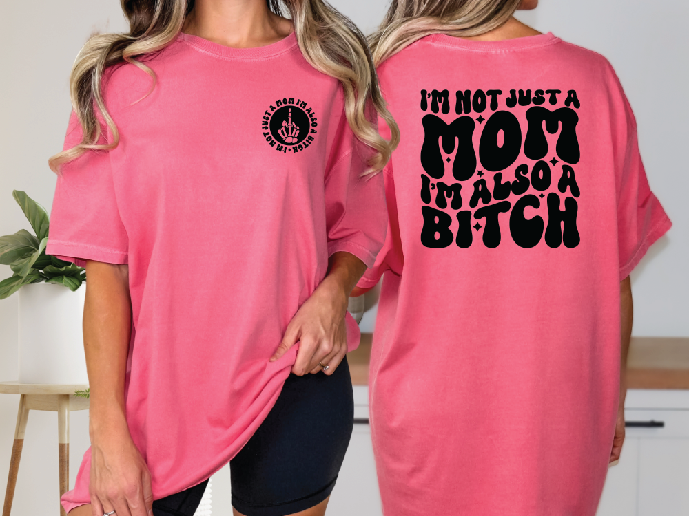 two women wearing pink shirts that say i'm not just a mom, i