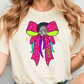 A woman wearing a white t-shirt with a colorful graphic design of a bow on it.
