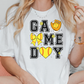 a woman sitting on a couch wearing a t - shirt that says game day