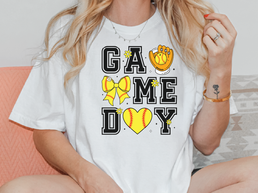 a woman sitting on a couch wearing a t - shirt that says game day