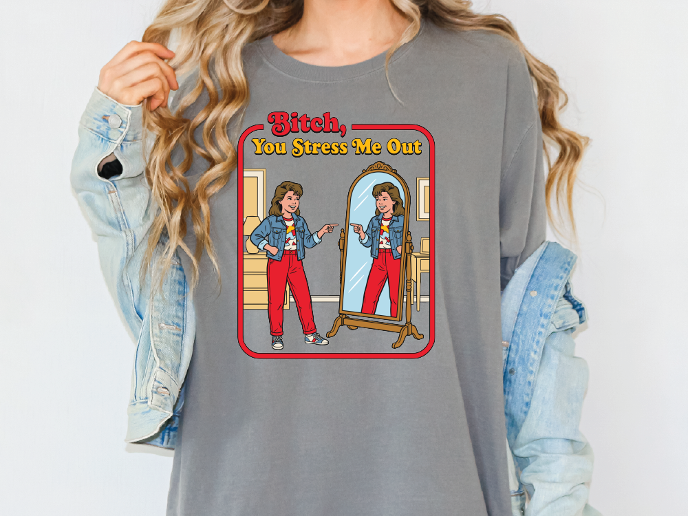 A person wearing a gray t-shirt with a graphic design depicting two women in a mirror, one of whom is described as "Bitch" and the other as "You Stress Me Out".