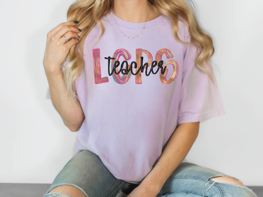 a woman sitting on the floor wearing a t - shirt that says teacher