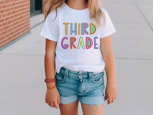 a young girl wearing a third grade t - shirt