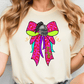 A woman wearing a white t-shirt with a colorful graphic design featuring a bow and a helmet.