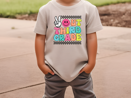 a young boy wearing a t - shirt that says out third grade