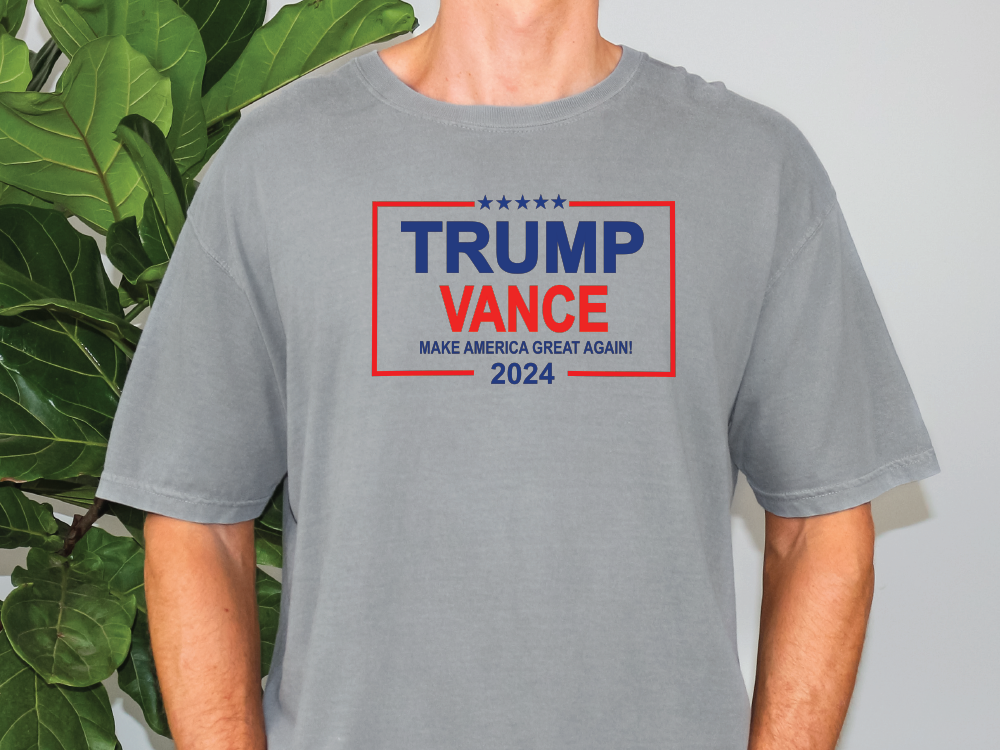 a man standing in front of a plant wearing a trump t - shirt