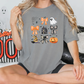 a woman sitting on a bed wearing a halloween t - shirt