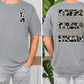 a man wearing a gray t-shirt with a camouflage pattern and text on the back.