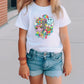 a little girl wearing a white shirt and denim shorts