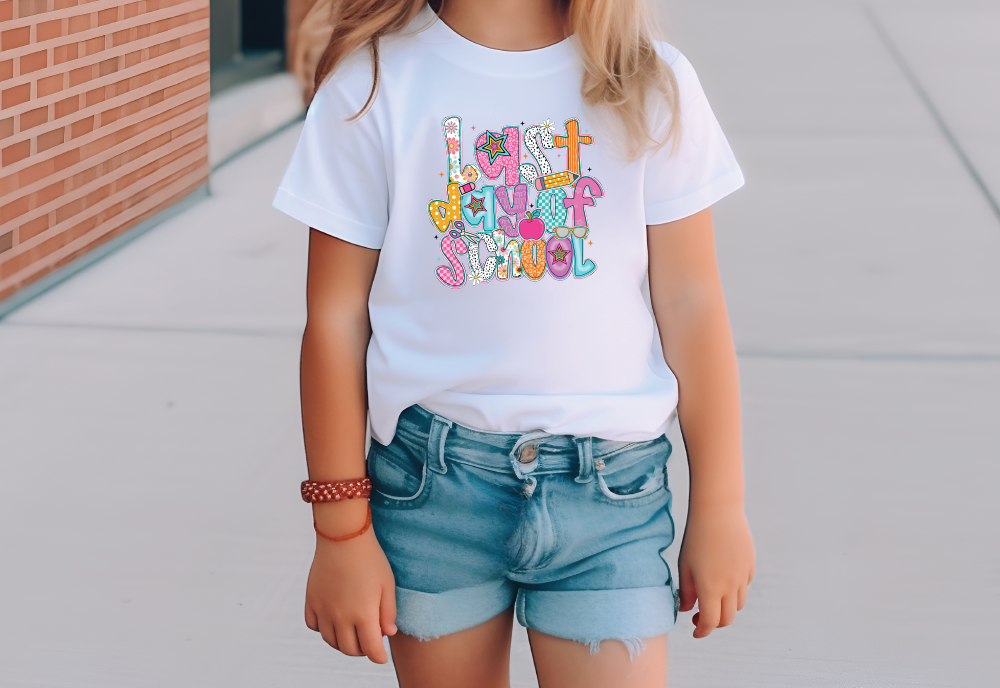 a little girl standing on a sidewalk wearing a white t - shirt