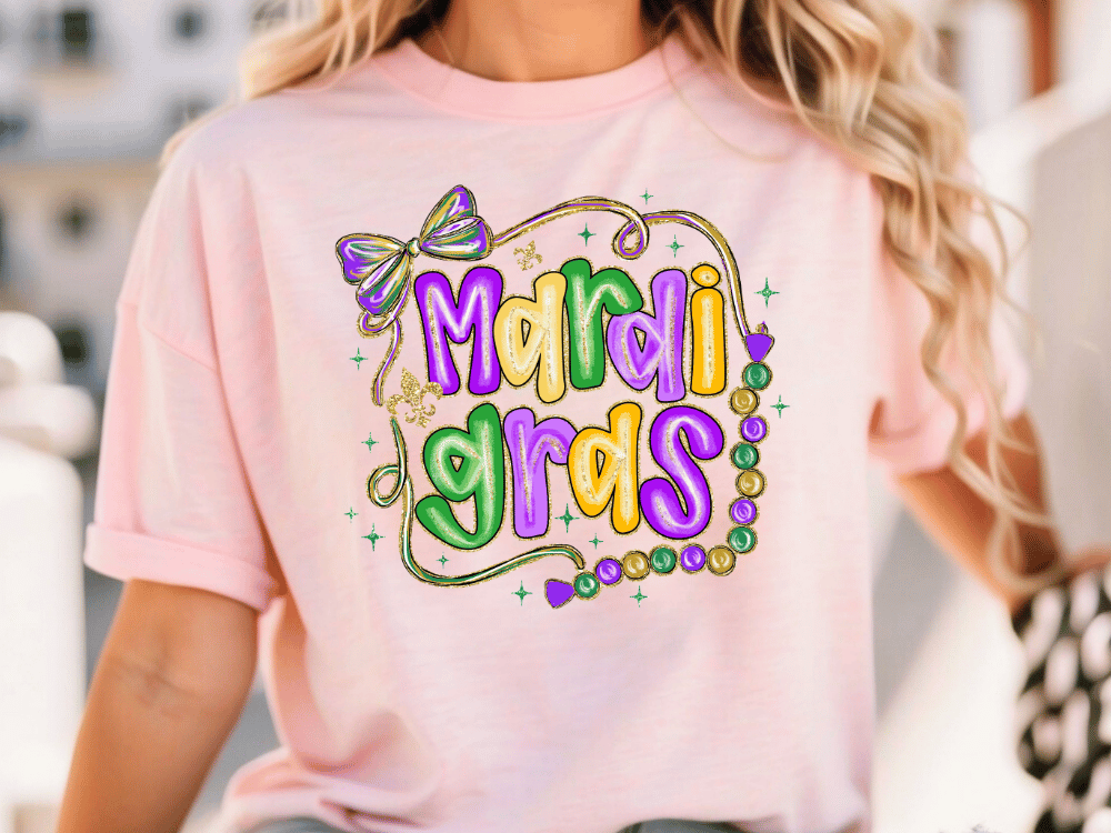 A woman wearing a pink t-shirt with the text "Mardi Gras" printed on it.