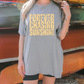 a woman standing in front of a boat wearing a shirt that says forever chasing sunshine