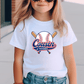 A young girl wearing a white t-shirt with a baseball graphic and the text "Cousin of the Rookie" printed on it.