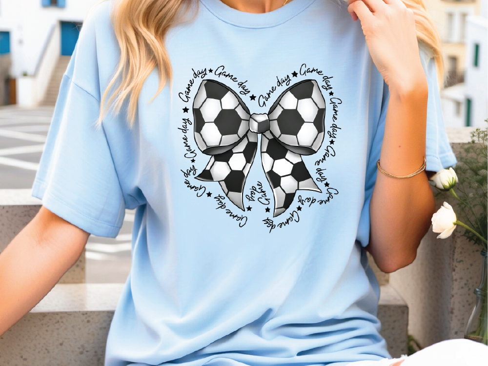 a woman wearing a blue shirt with a soccer ball on it