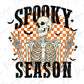 a skeleton holding two bats with the words spooky season on it