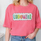 a woman standing in front of a wall wearing a pink shirt that says ludo