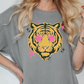 A woman wearing a gray t-shirt with a graphic design of a tiger's face and pink stars.