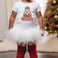 a little girl standing in front of a christmas tree