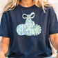 A woman wearing a navy blue t-shirt with a graphic design of a blue and white patterned bag with a bow on it.