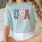 a woman sitting on a bed wearing a usa t - shirt