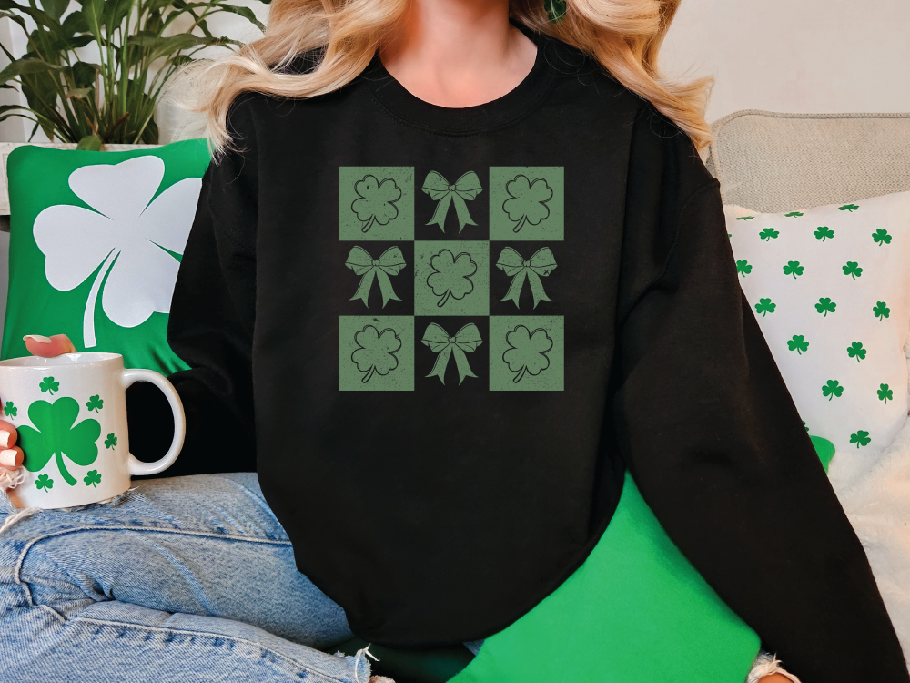 a woman sitting on a couch wearing a black sweater with shamrocks on it