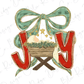 a nativity scene with a baby in a wooden basket, surrounded by a green bow and red letters spelling "Joy".